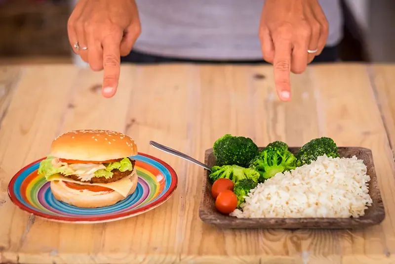 Pessoa diante de alimentos industrializados em um episódio de fome emocional
